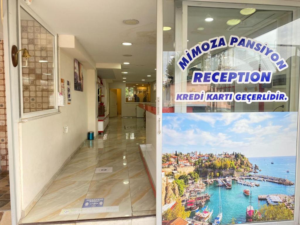 a building with a sign that reads puerto panacion and a picture at Mimoza Pansiyon in Antalya