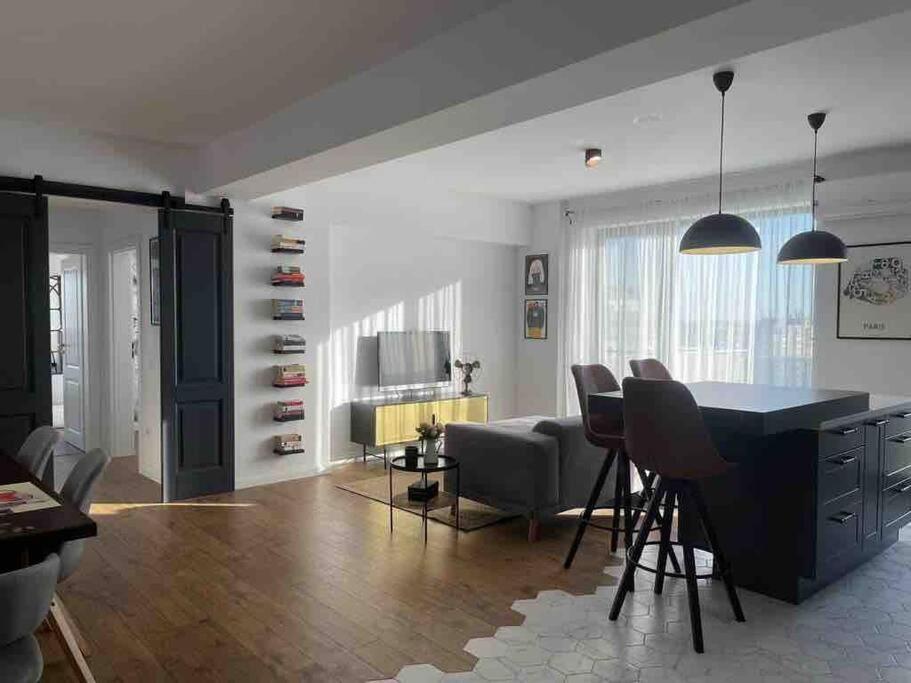 克拉約瓦的住宿－Modern 2-bedroom apartment in new residence，客厅设有厨房、桌子和椅子