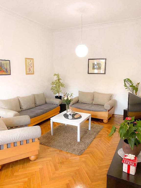 a living room with two couches and a table at Bueno Apartment in Belgrade