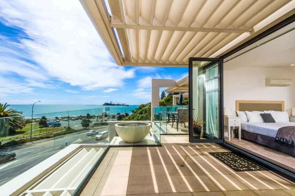 a bedroom with a view of the ocean at Silver Sands - Beachside Apartment in Nelson