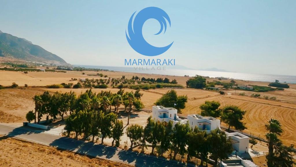 an aerial view of a resort with trees and the ocean at Marmaraki Village House & Apartments in Kardamaina