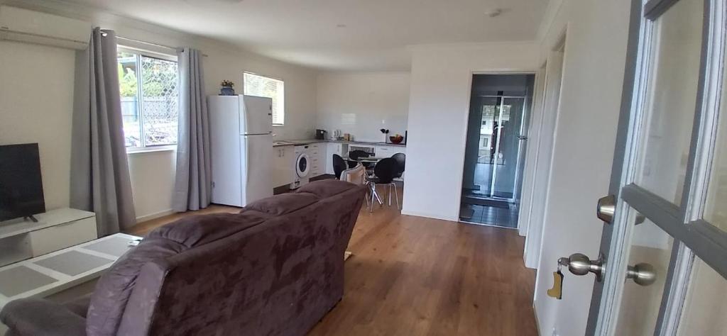 a living room with a couch and a kitchen at Rising Sun in Russell Island