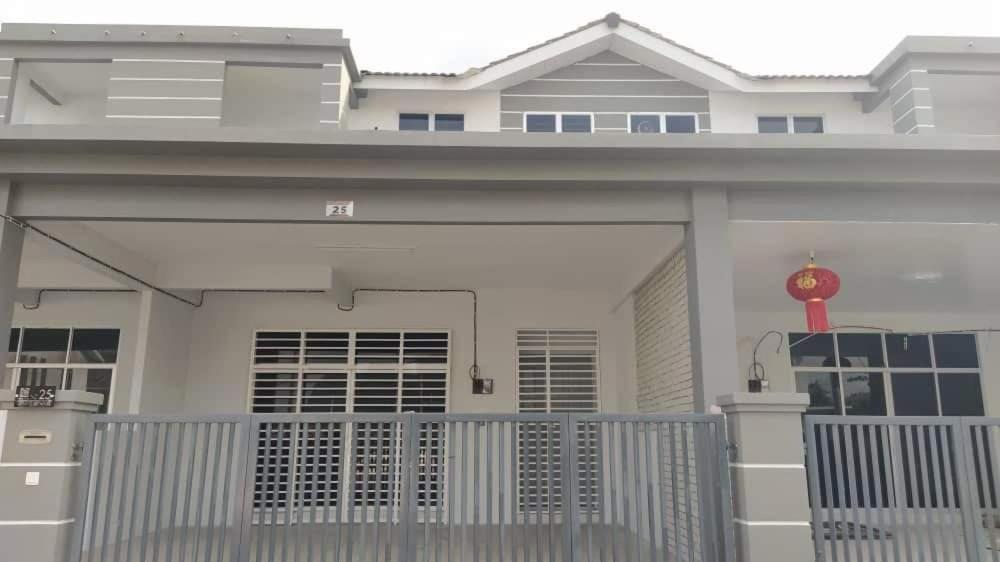 a large white house with a gate and a redozy at Afiyah Guesthouse in Padang Besar