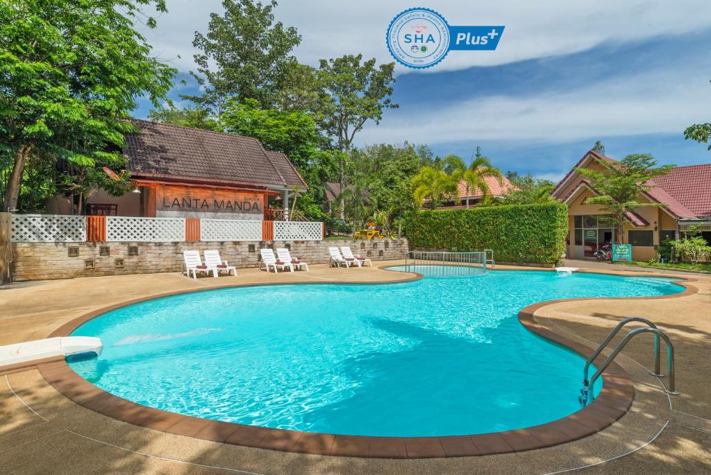 - une piscine dans une cour avec des chaises et une maison dans l'établissement Lanta Manda Resort, à Ko Lanta