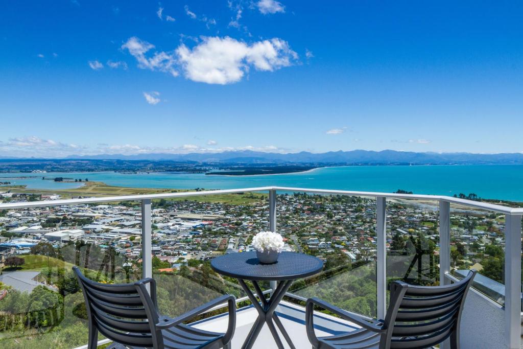 a balcony with a table and chairs and a view of a city at Tasman Bay Villa in Nelson