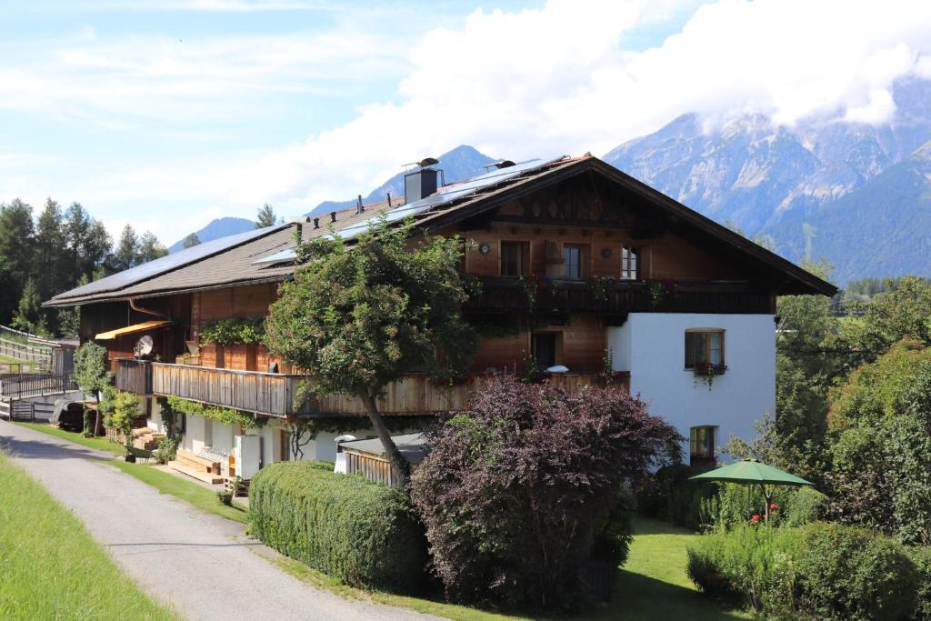 ein großes Holzhaus mit Bergen im Hintergrund in der Unterkunft Pechhof in Innsbruck