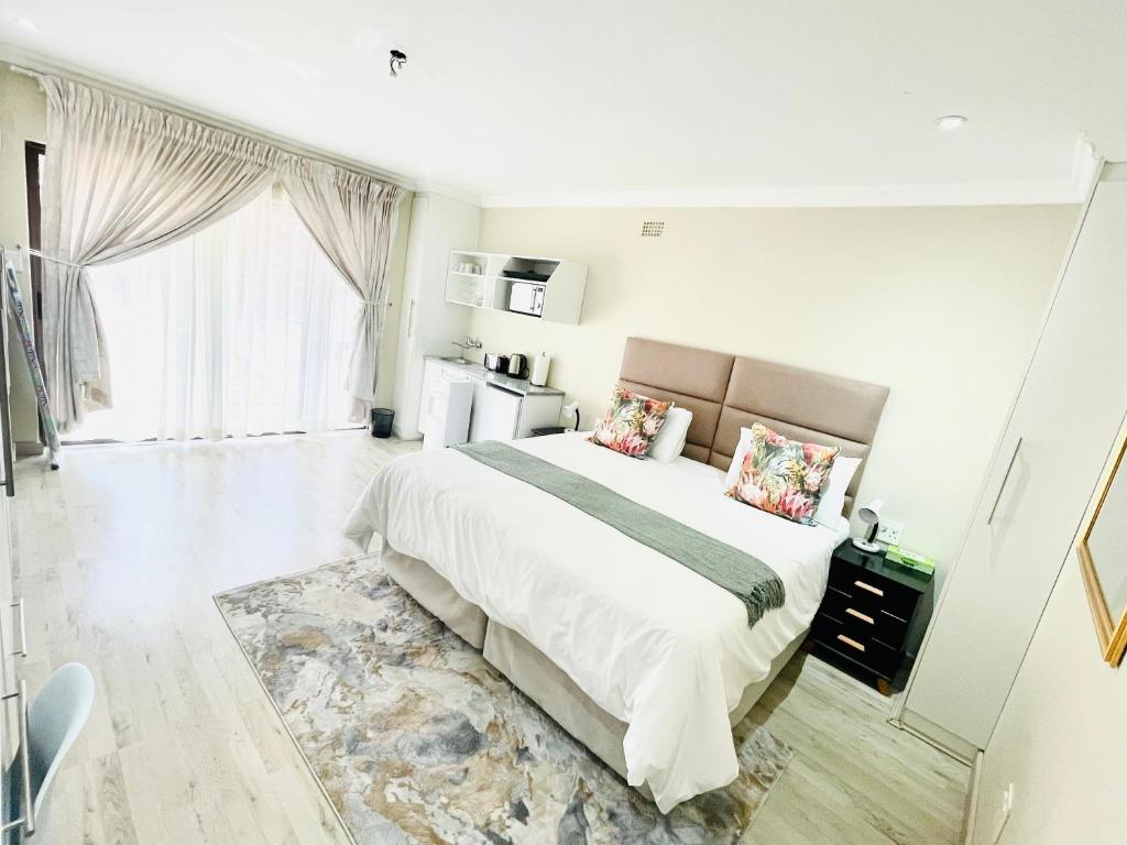 a bedroom with a large bed and a large window at C&C HOTEL VIBES Randpark Ridge JHB 14 Units Available in Boskruin