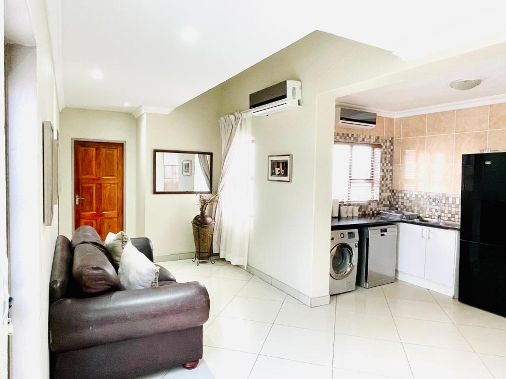 a living room with a couch and a kitchen at C&C HOTEL VIBES Randpark Ridge JHB 14 Units Available in Boskruin