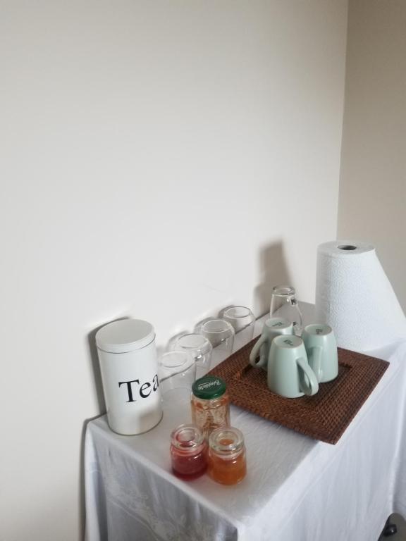 a table with tea pots and jars on it at Côté Grange in Tournai