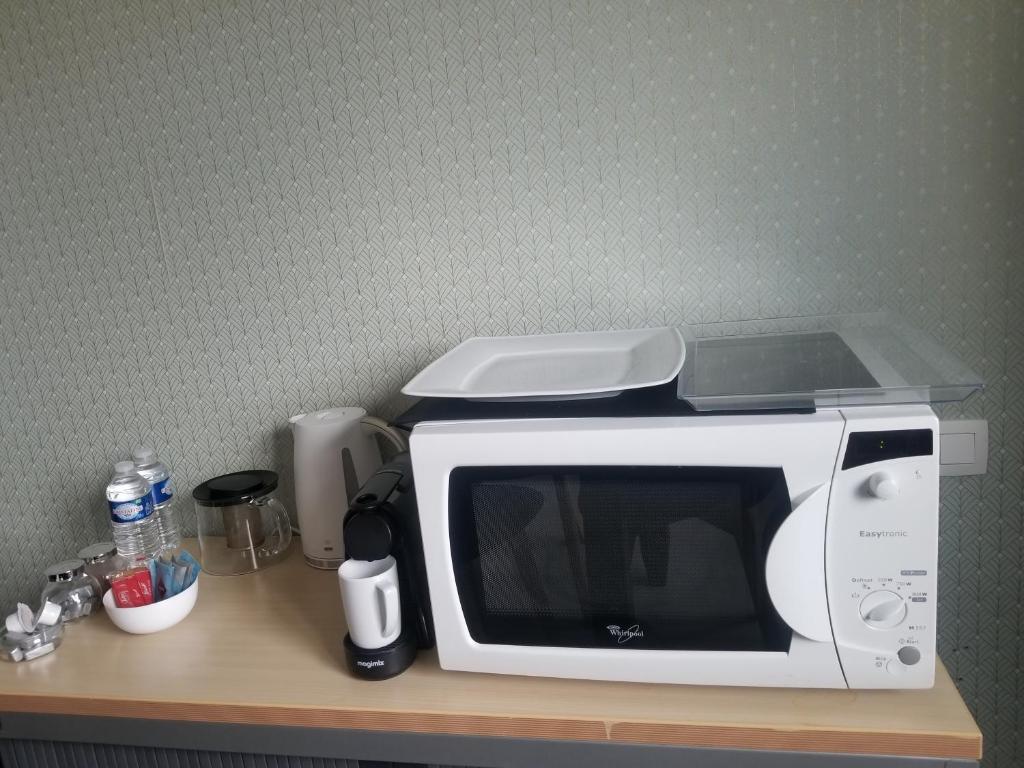 a white microwave sitting on top of a counter at Côté Grange in Tournai