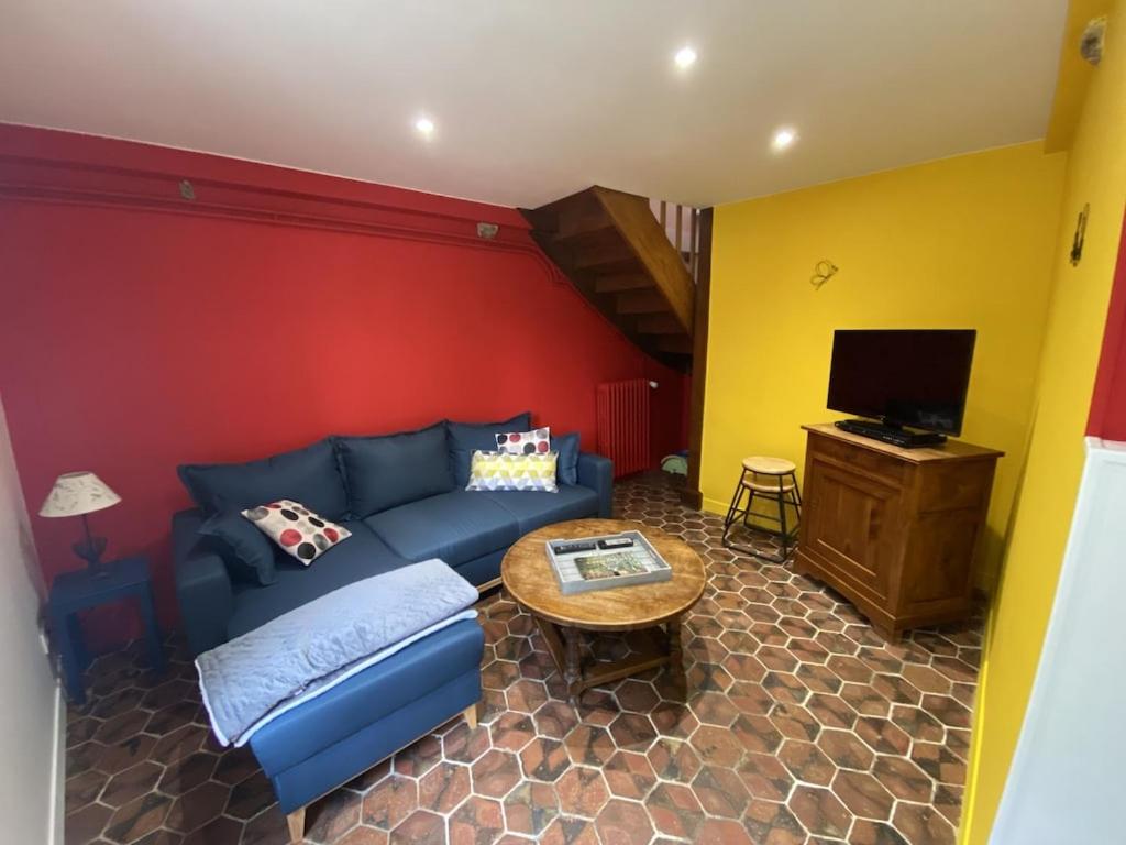a living room with a blue couch and a table at La Petite Maison - Maison de Campagne aux portes du Perche in Irai