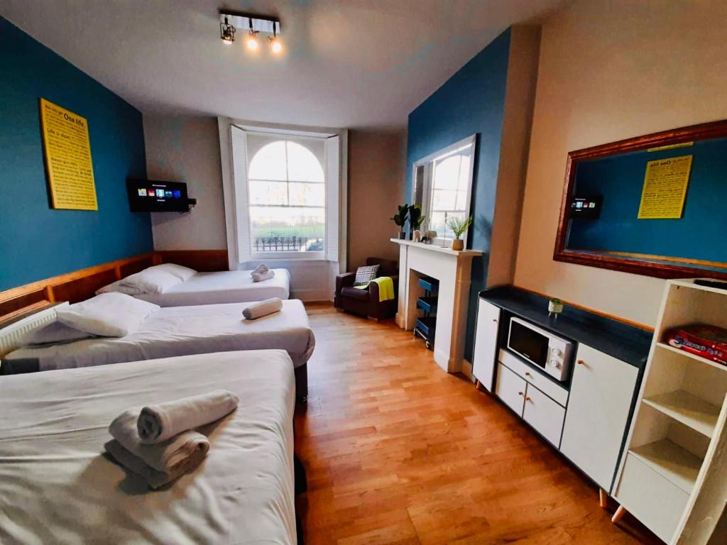 ロンドンにあるKX Rooms Kings Crossのベッド2台、薄型テレビが備わる客室です。