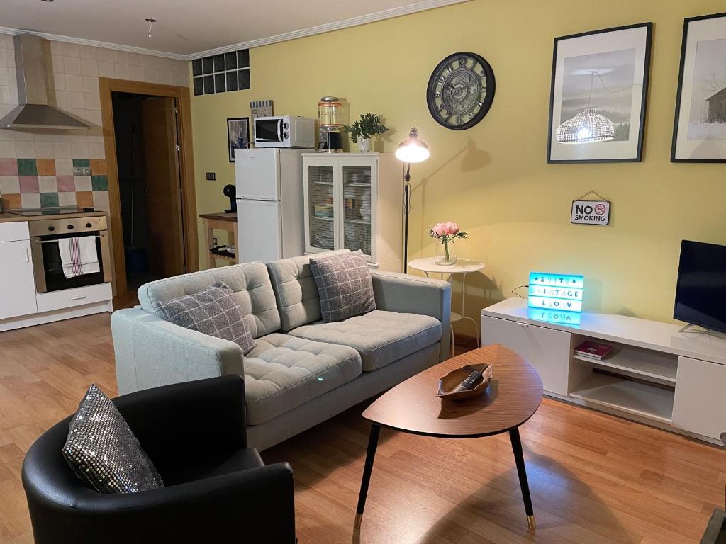 ein Wohnzimmer mit einem Sofa und einem Tisch in der Unterkunft SUITE VINTAGE LEON in León