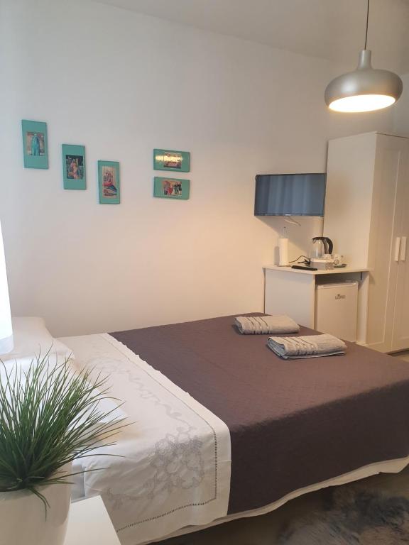 a bedroom with a large bed and a kitchen at Miriam Rooms Zadar in Zadar