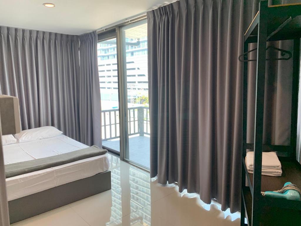 a small bedroom with a bed and a balcony at Udomsuk Inn & Cafe Since 2019 - BTS Udomsuk in Bangkok