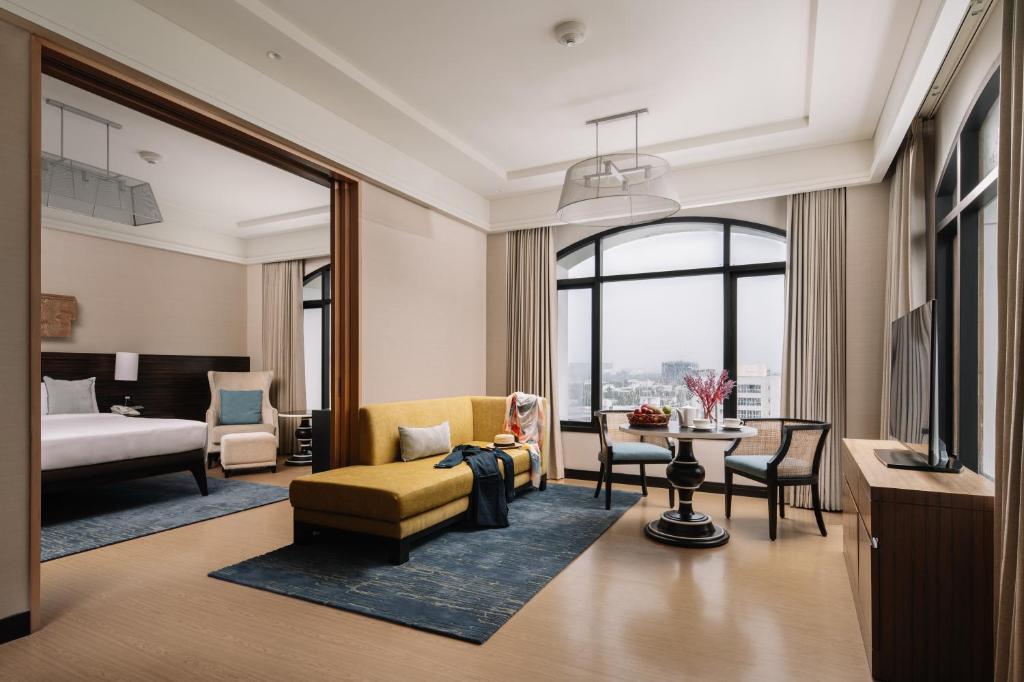 a hotel room with a bed and a living room at The Raintree, St. Mary’s Road in Chennai