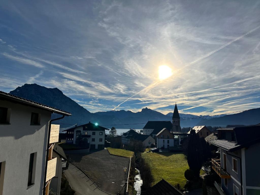 a view of a town with the sun in the sky at Neues Traunsee Apartment Altmünster in Altmünster