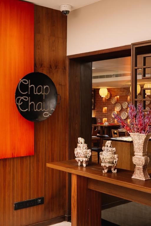 a dining room with a table with a vase of flowers at The Raintree, St. Mary’s Road in Chennai