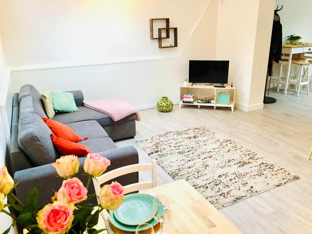 ein Wohnzimmer mit einem Sofa und einem Tisch in der Unterkunft Chaleureux et spacieux appartement de centre-ville - Lit King Size - NETFLIX in Cherbourg en Cotentin