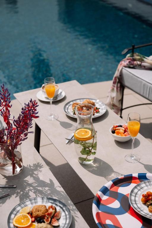 a table with plates of food and glasses of orange juice at The Raintree, St. Mary’s Road in Chennai