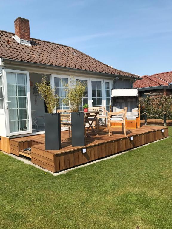 a deck with a table and chairs in a yard at Kleines, feines Domizil - 500m von der Strandpromenade in Dahme