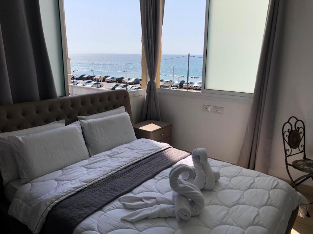 Schlafzimmer mit einem Bett und Meerblick in der Unterkunft Hotel Room Service in Bat Yam