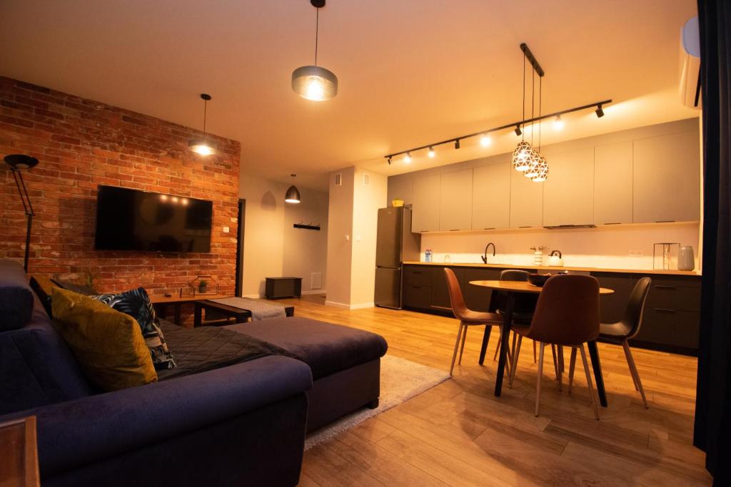 a living room with a couch and a table and a kitchen at Schneidemühl Premium Apartments in Piła