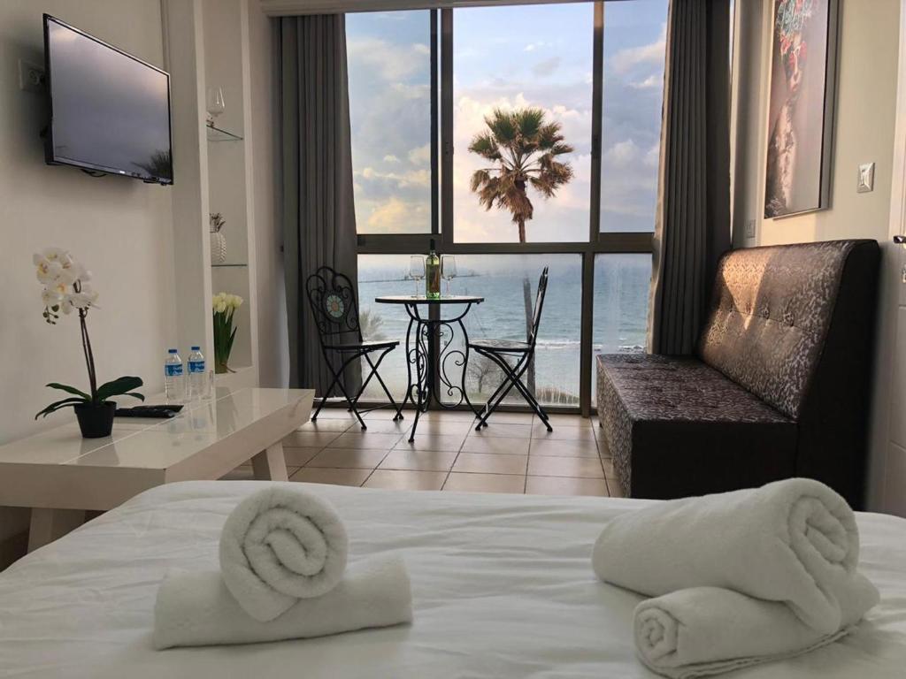 a hotel room with a bed and a view of the ocean at Sea Line Hotel From R&A Group in Bat Yam