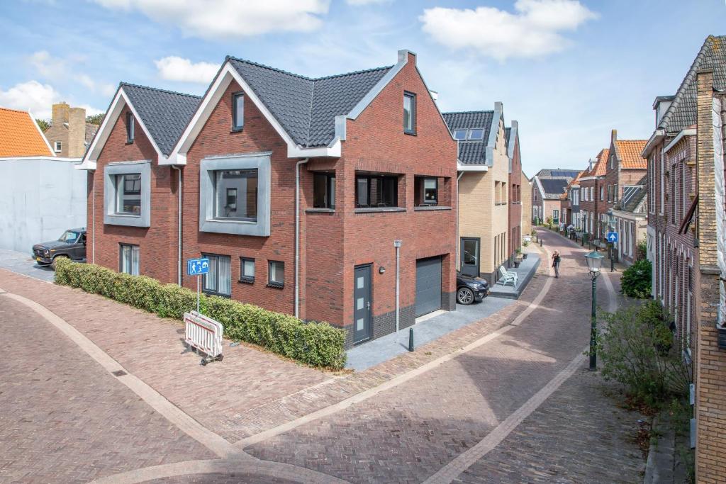 une rue avec des maisons en briques sur une route en briques dans l'établissement Bed & Parking Burght van Texel, à Den Burg