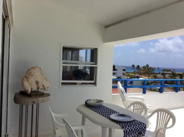 comedor con mesa y sillas y balcón en Edificio Sarie Bay, en San Andrés