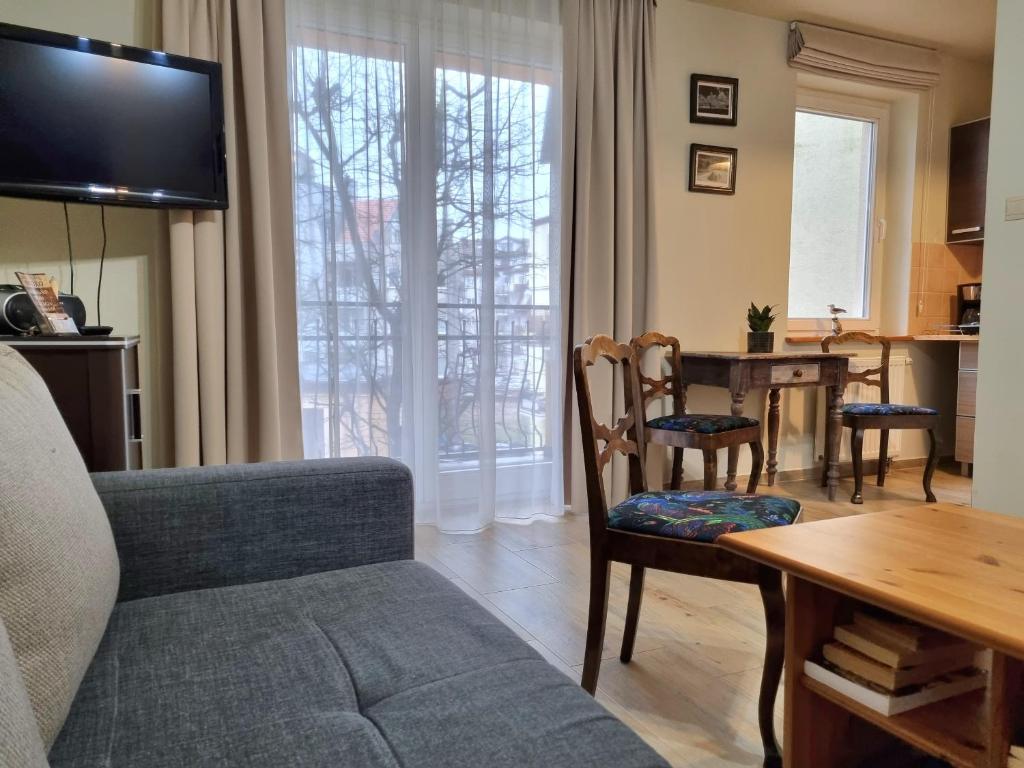 ein Wohnzimmer mit einem Sofa und einem Tisch in der Unterkunft Apartament w Porcie Kołobrzeg latarnia morska plaża molo w zasięgu ręki in Kołobrzeg