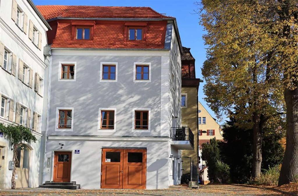 ein weißes Haus mit rotem Dach in der Unterkunft Wassergasse 11 in Regensburg