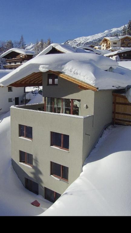 pokryty śniegiem budynek ze śniegiem w obiekcie Chalet Lenzi w mieście Sankt Anton am Arlberg