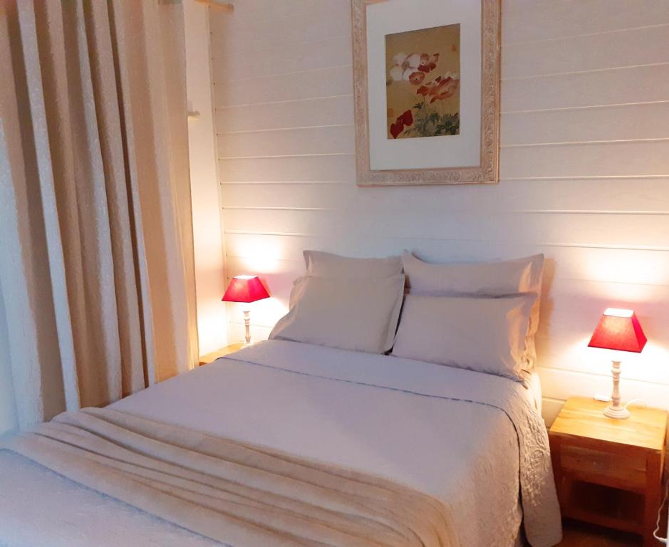 um quarto com uma cama branca e 2 candeeiros em Tourny - Studio cosy Centre médiéval Sarlat em Sarlat-la-Canéda
