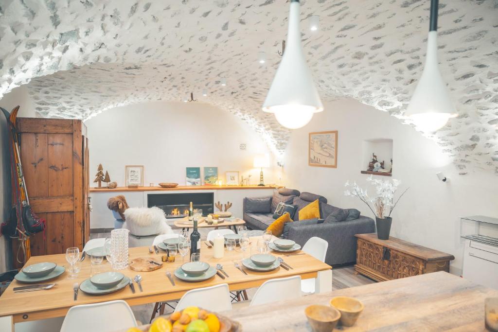 a living room with a table and a couch at Maison de village - Les Voûtes Blanches - Serre Chevalier 1350 in Saint-Chaffrey