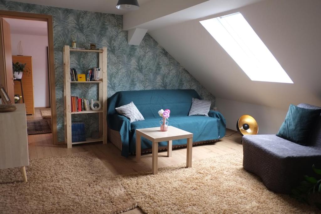 Apartman Katarina في زغرب: غرفة معيشة مع أريكة زرقاء وطاولة