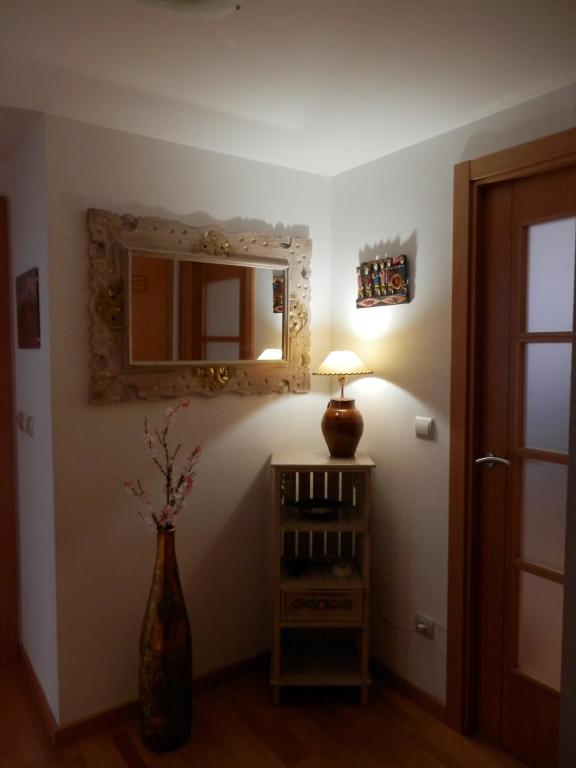 ウエスカにあるAcogedor Apartamento En Huescaの花瓶、ランプ、鏡付きの部屋