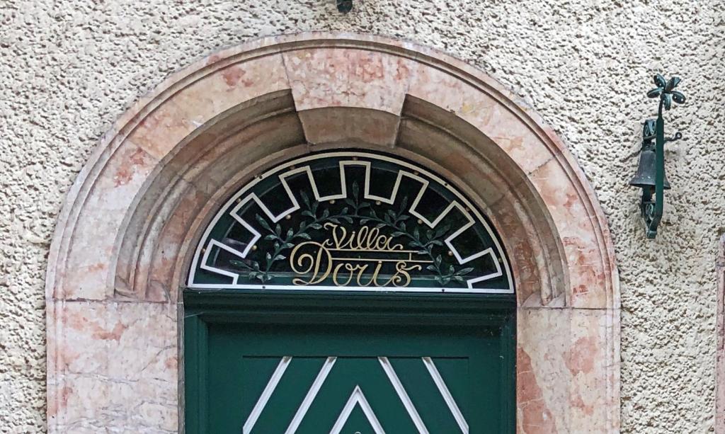 una puerta verde con una señal encima de ella en un edificio en Villa Doris, en Berchtesgaden