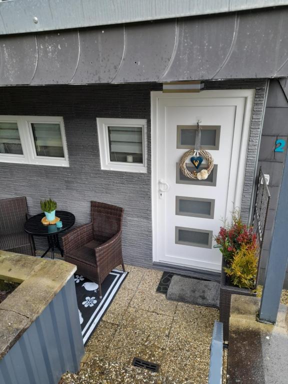 a front door of a house with a chair and a table at Haus Eifel in Kerschenbach