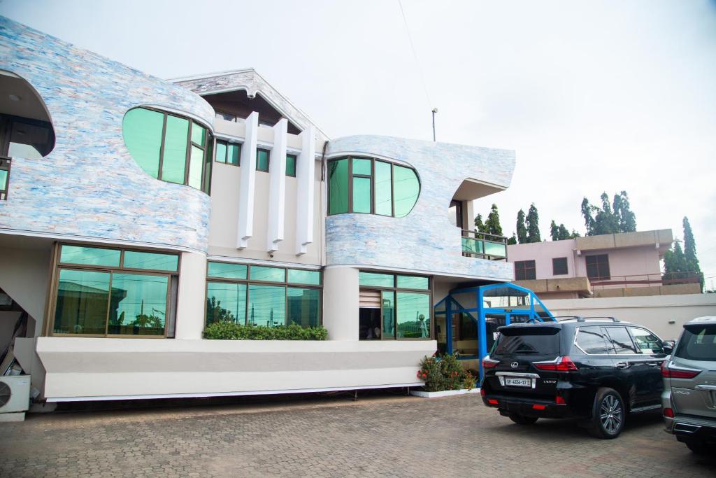 a car parked in a parking lot in front of a building at Sam's Cottage Hotel in Dzorwulu