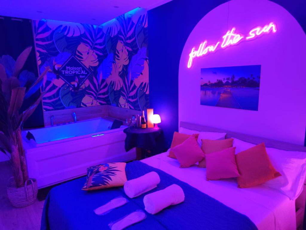 Schlafzimmer mit einem Bett mit Neonschild in der Unterkunft Suite Maison Tropical - Luxury Apartment in Bari in Bari