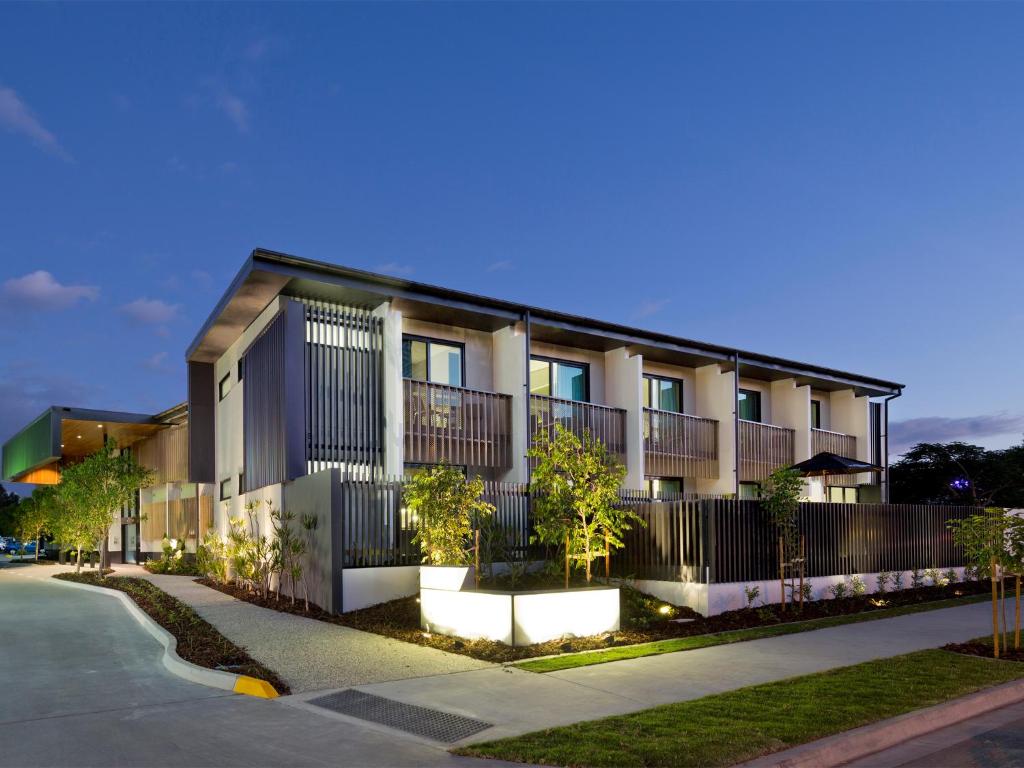 a building with a fence in front of a street at Glen Hotel and Suites in Brisbane