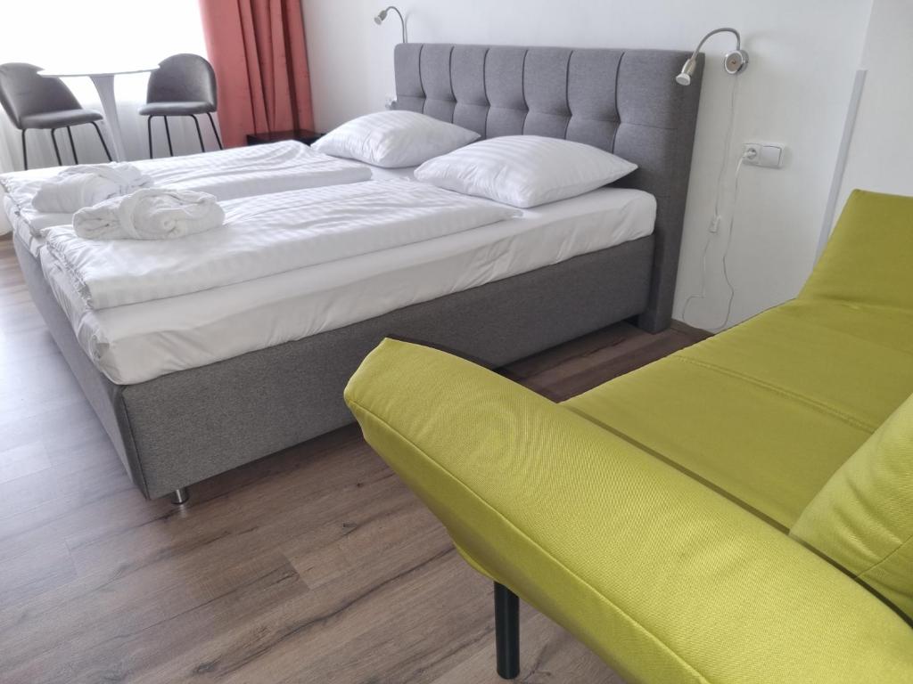 ein Schlafzimmer mit einem großen Bett und einem gelben Stuhl in der Unterkunft Ubytování Hanka v hotelovém pokoji C408 in Frymburk