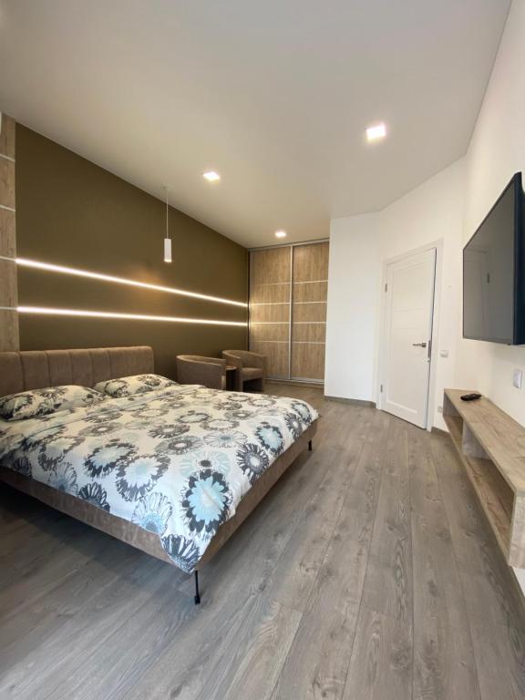 1 dormitorio con 1 cama y TV de pantalla plana en Чудова квартира в центрі міста, en Rivne