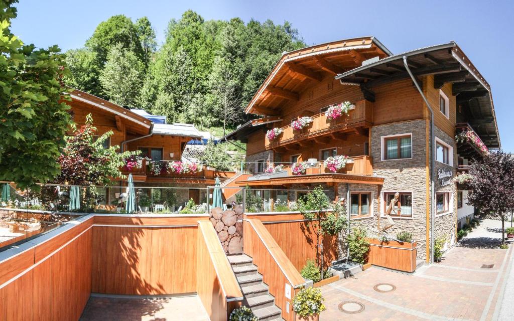 a house with a balcony with flowers on it at TALHEIMER Grias di & Hoamat since 1958 inklusive Therme TAUERN SPA & Jokercard in Saalbach Hinterglemm