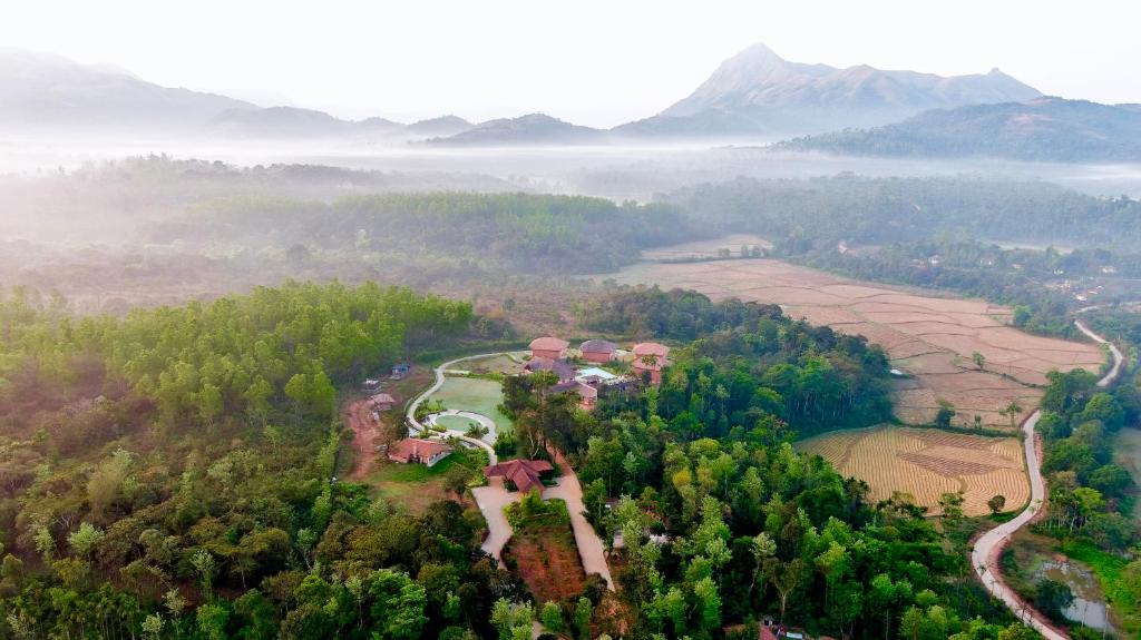 Machaan Plantation Resort, Sakleshpur في ساكليشبور: اطلالة جوية لمنتجع وسط غابة