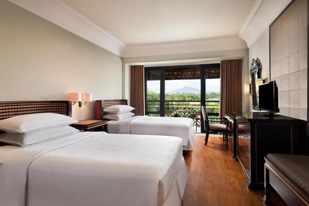 Postel nebo postele na pokoji v ubytování Mustika Yogyakarta Resort and Spa