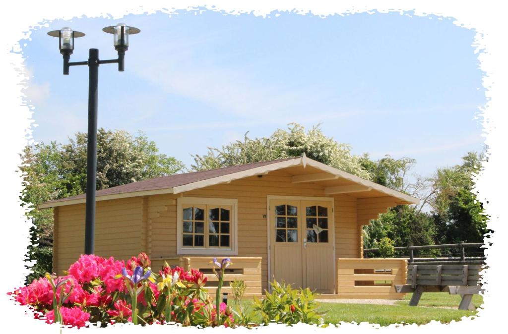 a small house with a bench and flowers at Domaine De Soignolles in Soignolles