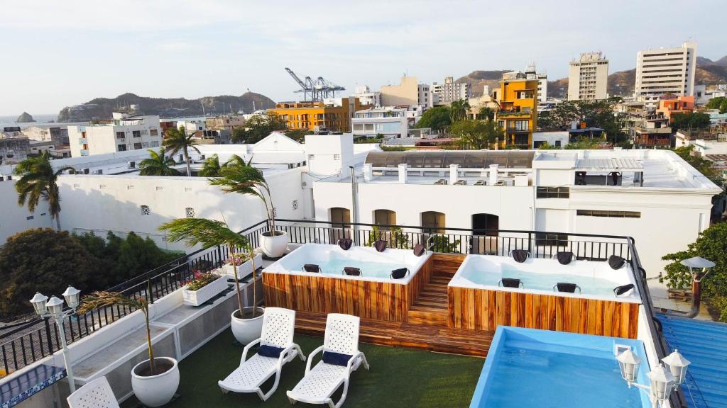 a balcony with chairs and a swimming pool on a building at Hotel Parque de los Novios Inn in Santa Marta