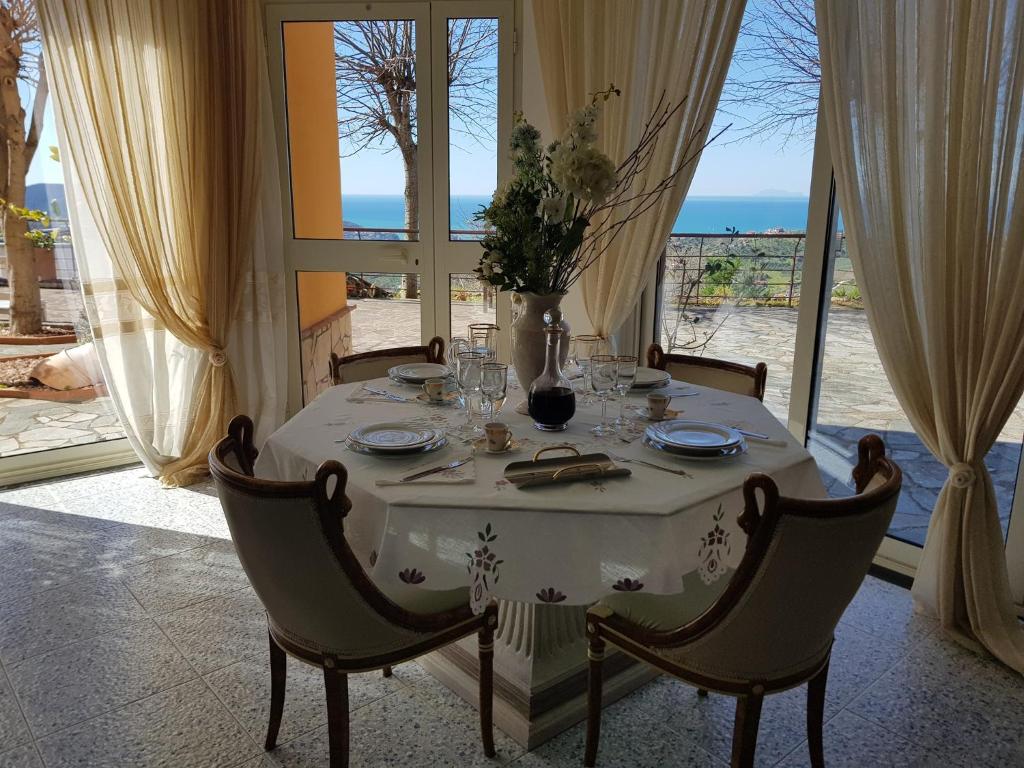 una mesa con un mantel blanco y un jarrón en ella en B&B Il giardino di Armida en Ogliastro Cilento